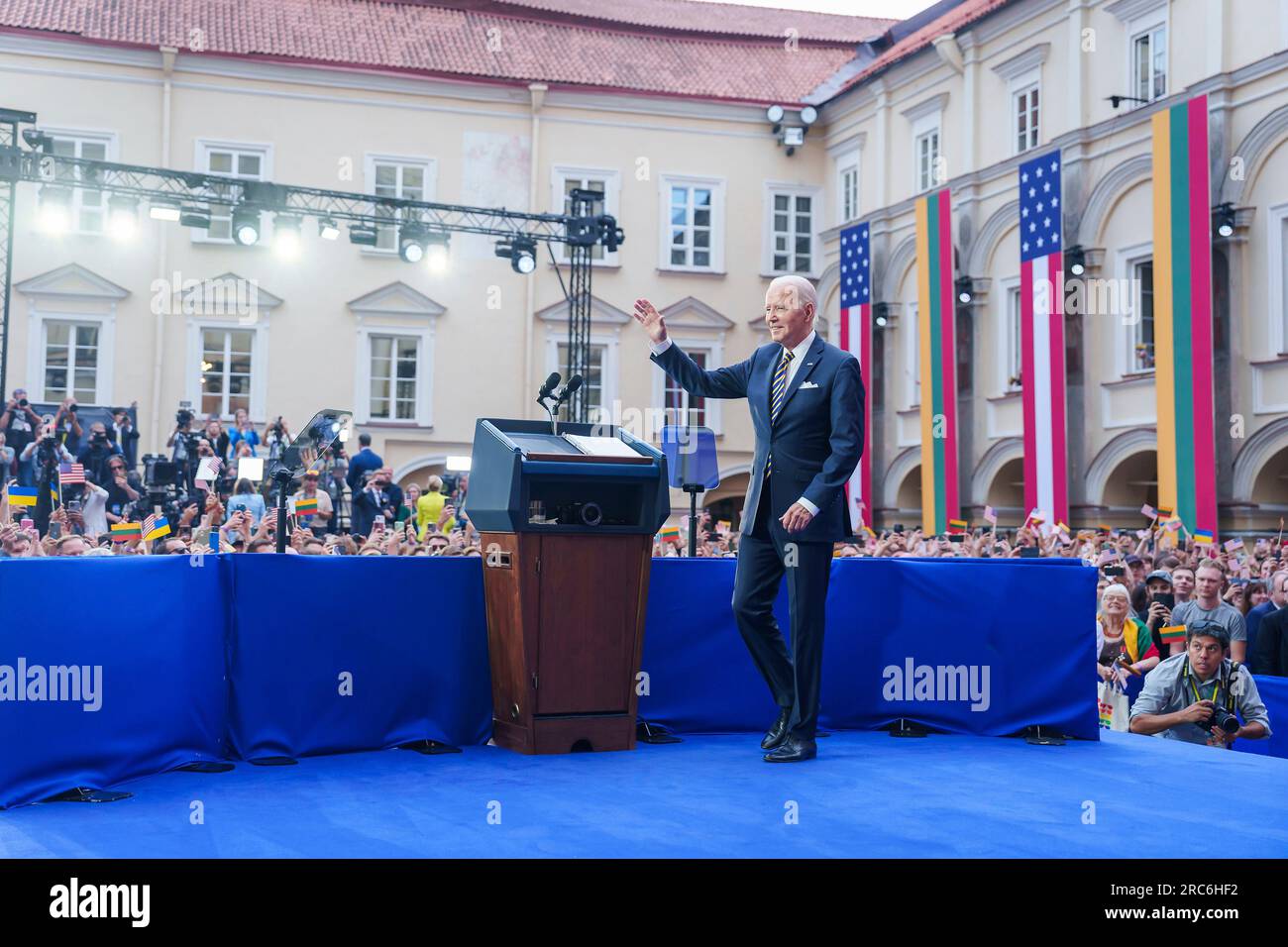 Vilnius, Lituanie. 12 juillet 2023. Le président américain Joe Biden fait signe à la foule alors qu’il arrive sur scène pour prononcer un discours devant les nations lituanienne et ukrainienne refusant de s’incliner devant l’agression russe à l’Université de Vilnius à la suite du sommet de l’OTAN, le 12 juillet 2023 à Vilnius, en Lituanie. Une foule estimée à 10 000 personnes agite des drapeaux lituaniens, américains et ukrainiens et applaudit le président. Crédit : Adam Schultz/White House photo/Alamy Live News Banque D'Images