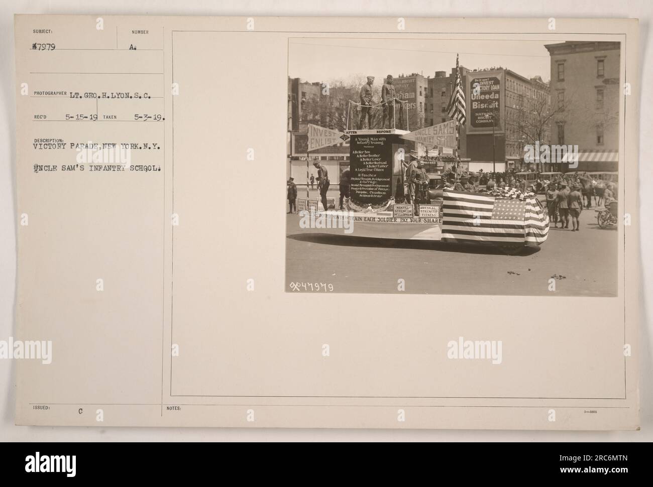 Des soldats de l'école d'infanterie de l'oncle sa marchent dans un défilé de la victoire à New York, NY. La photographie a été prise le 3 mai 1919 par le lieutenant Geo. H. Lyon, S.C. L'image montre un jeune soldat dans une courte coiffure posée devant une bannière publicitaire Uneeda Biscuit. Banque D'Images