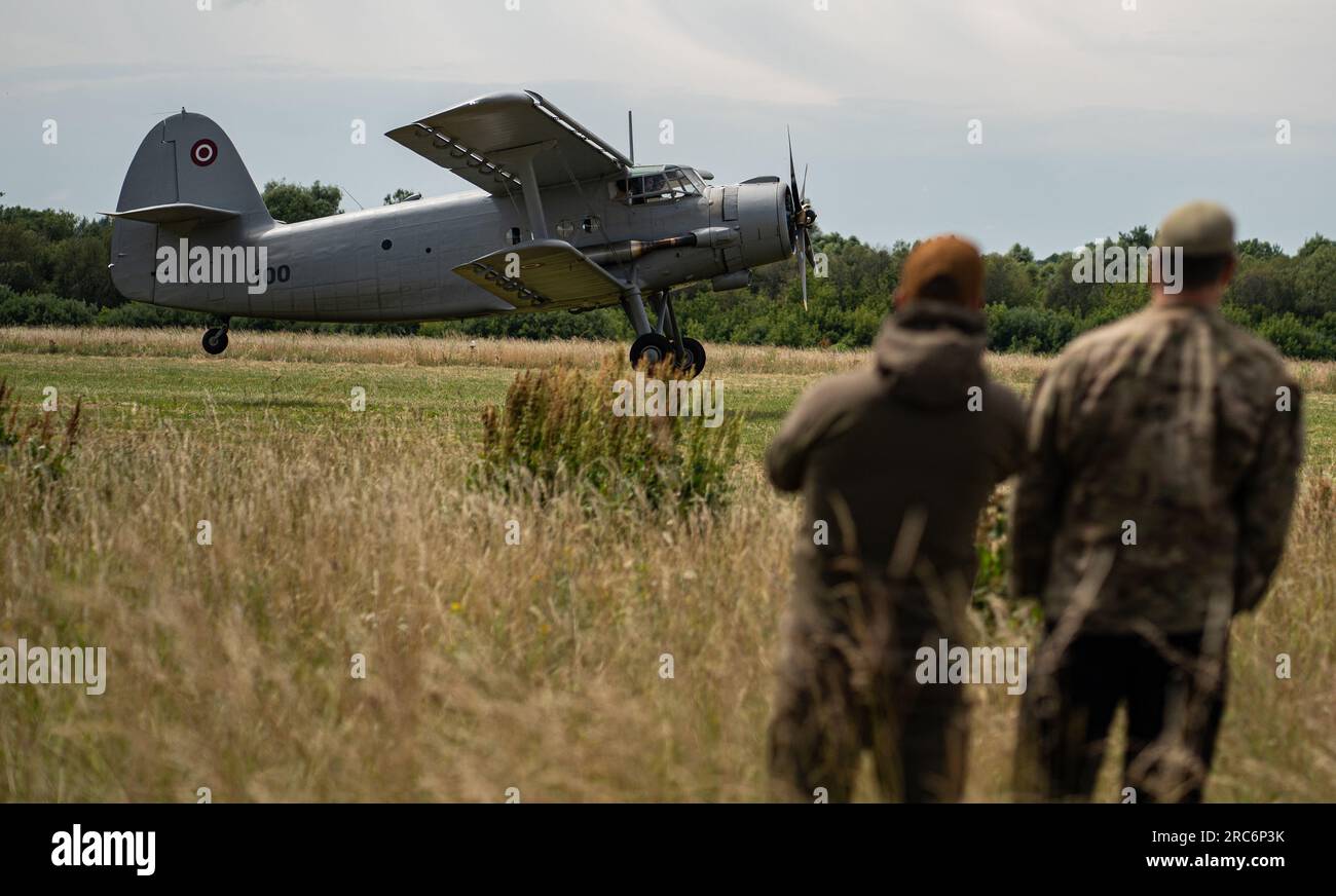 Un avion AN-2 letton se prépare à atterrir sur une piste d'assaut en herbe en tant que U.S. Les forces d'opérations spéciales observent pendant les opérations spéciales l'entraînement à l'intégration air-terre près de Daugavpils, Lettonie, le 28 juin 2023. Il ne s’agit pas seulement de disposer des forces et des capacités adéquates sur le théâtre, mais aussi d’exercer notre capacité à recevoir rapidement ces forces et à les intégrer à celles de nos alliés et partenaires. (Capitaine Kaitlyn Danner) Banque D'Images