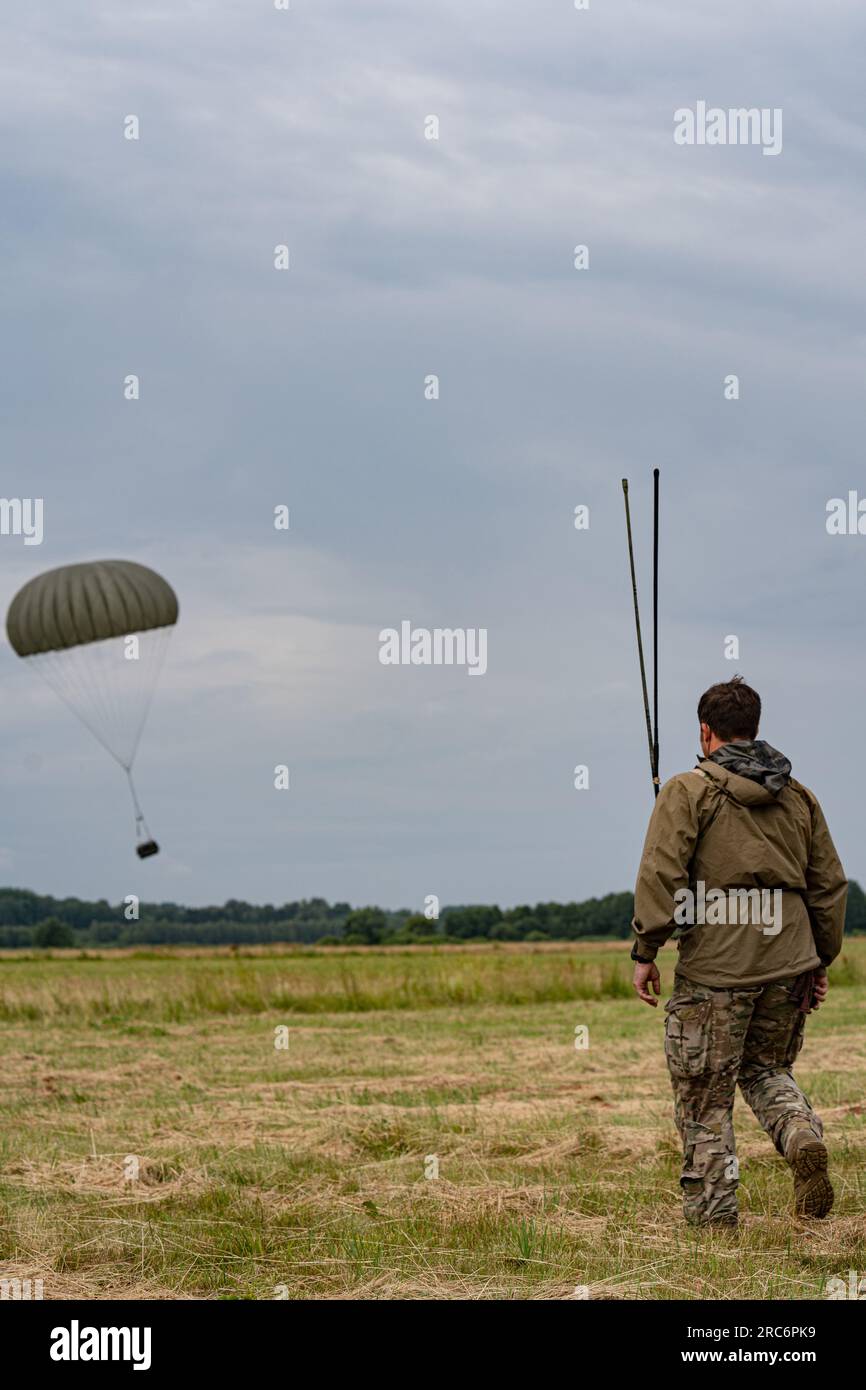 Un contrôleur de combat affecté à la 352e Escadre des opérations spéciales observe l'atterrissage d'un paquet de réapprovisionnement au cours d'un lieu d'entraînement à l'intégration air-terre des opérations spéciales près de Daugavpils, en Lettonie, le 28 juin 2023. Des activités efficaces de logistique et de mobilité, telles que mises en évidence dans les opérations et les exercices, renforcent directement notre capacité à soutenir nos alliés et partenaires et à réagir aux crises potentielles. (Capitaine Kaitlyn Danner) Banque D'Images