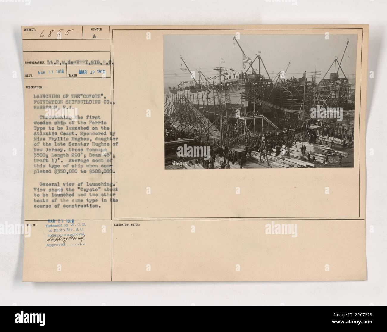Cette photographie montre le lancement du premier navire en bois du Ferris Type sur la côte atlantique. Le navire, nommé « Coyote », a été parrainé par Mlle Phyllis Hughes, fille du regretté sénateur Hughes du New Jersey. Il avait une jauge brute de 3500, une longueur de 290 pieds, une poutre de 46 pieds et un tirant d'eau de 17 pieds. Le coût moyen de ce type de navire se situait entre $350 000 et $500,000. L'image montre également deux autres bateaux du même type en construction. Banque D'Images