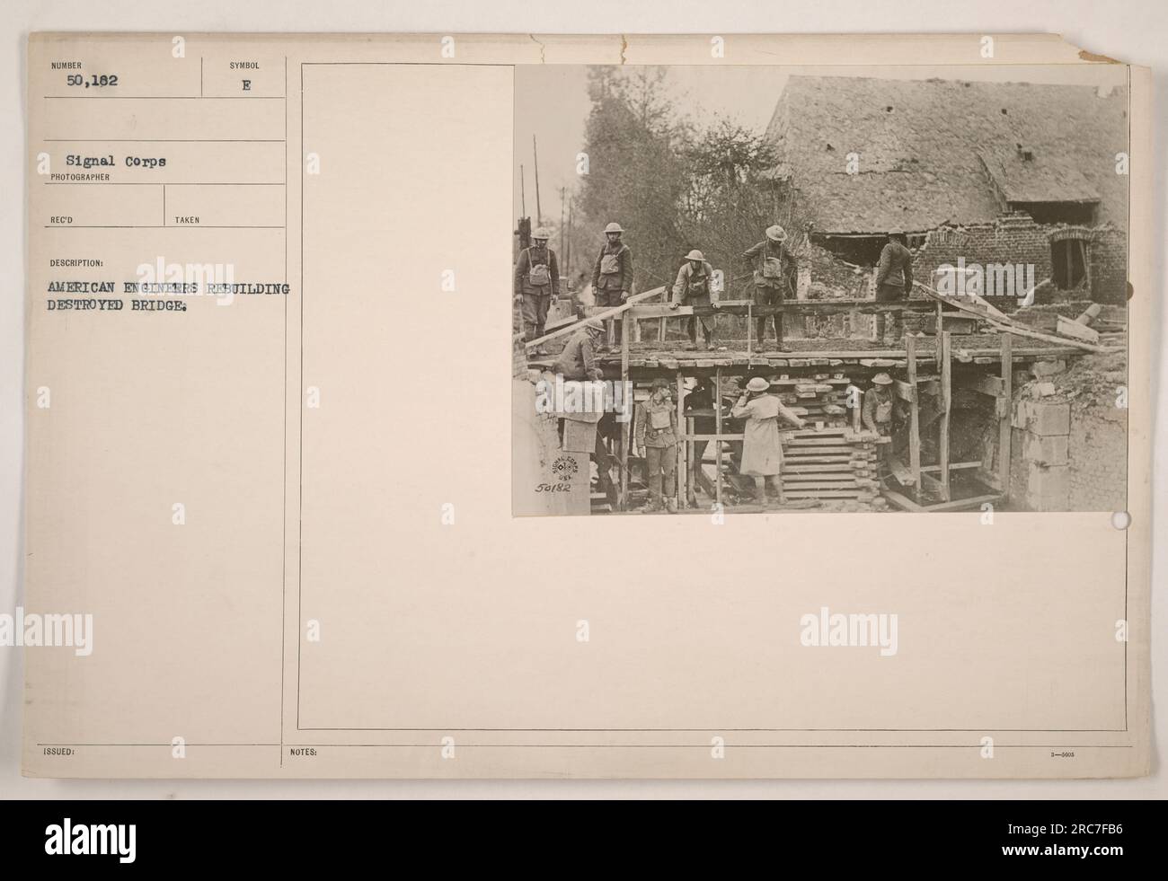Les ingénieurs américains travaillent ensemble pour reconstruire un pont détruit pendant la première Guerre mondiale. Leurs efforts démontrent la résilience et la détermination de l’armée américaine à restaurer les infrastructures vitales. Cette photographie a été prise par le photographe de signal corps Reco Takas. Banque D'Images