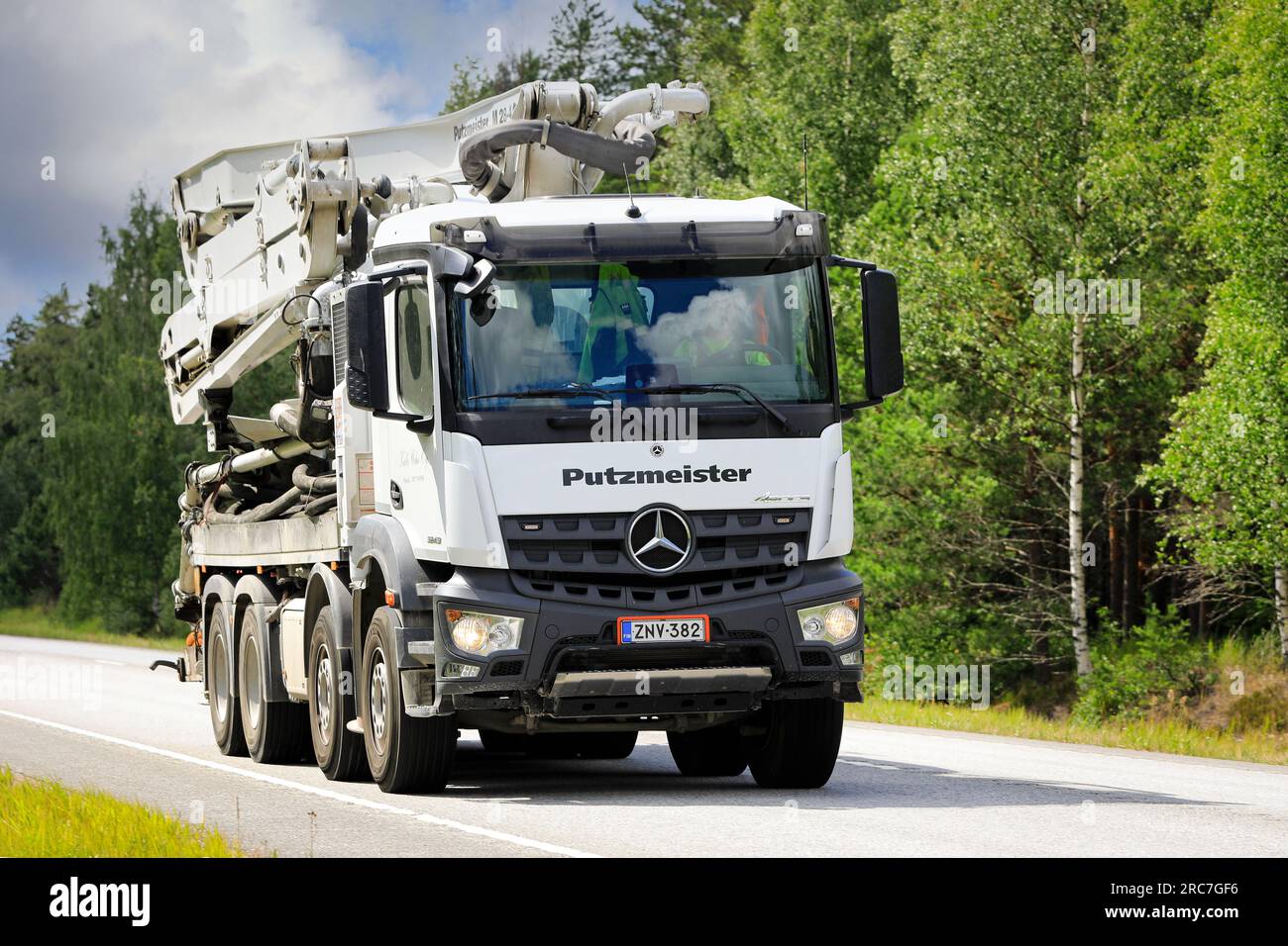 Camion blanc Mercedes-Benz Arocs 3243 avec pompe à béton Putzmeister M28-4 Pumi montée sur camion sur la route 25 à Raasepori, Finlande. 7 juillet 2023. Banque D'Images