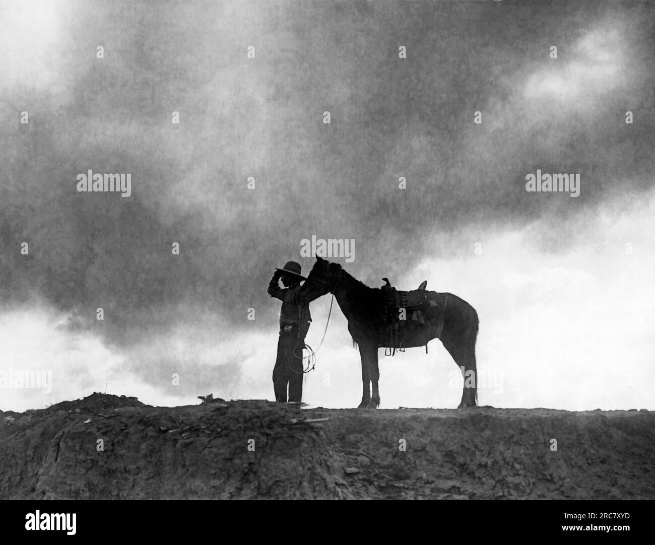 Arizona, 1910 Un Amérindien Navajo et son cheval au sommet d'un plateau au lever du soleil. Banque D'Images