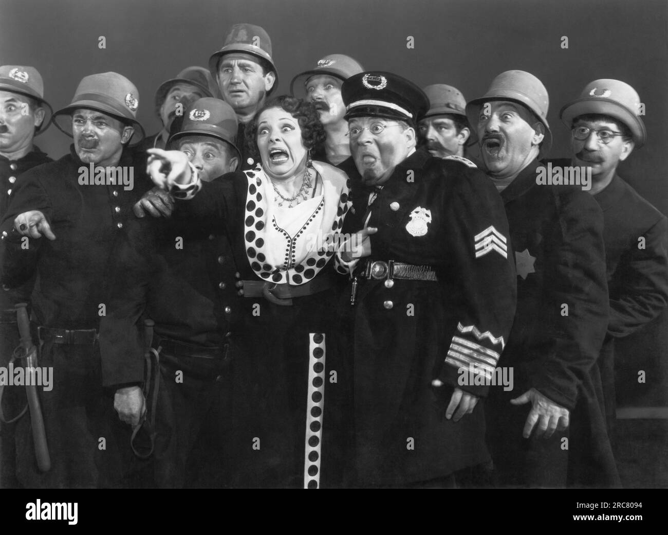 Hollywood, Californie : 1939 l'actrice Marjorie Beebe et la police sont terrifiées dans cette scène de Hollywood cavalcade. Banque D'Images