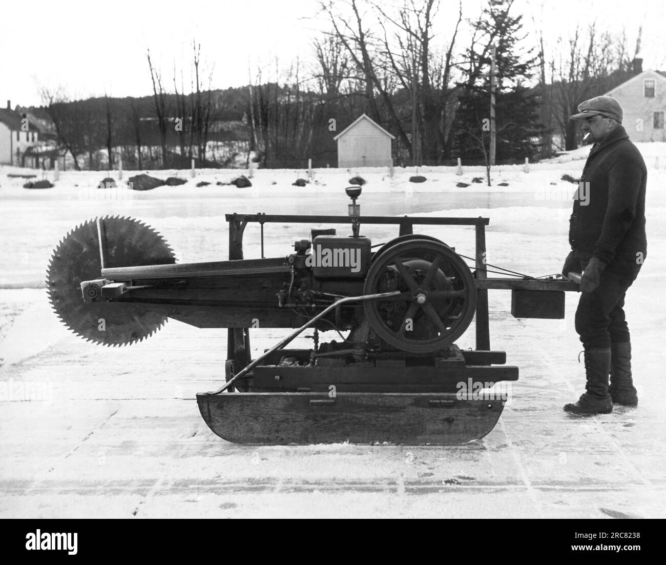 Norvège, Maine : c. 1929 cordonnier de métier, cet homme créa une machine pour couper des blocs de glace afin de compléter ses revenus pour sa famille de dix personnes. Avec une scie circulaire et un moteur à essence monté sur des coureurs, il coupe plus de 1000 gâteaux de glace par jour. Banque D'Images