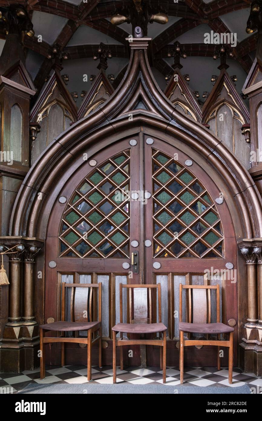 Intérieur de l'église de St. Anne dans la vieille ville de Vilnius, avec une vieille porte voûtée avec un beau cadre en bois bloqué par des chaises Banque D'Images