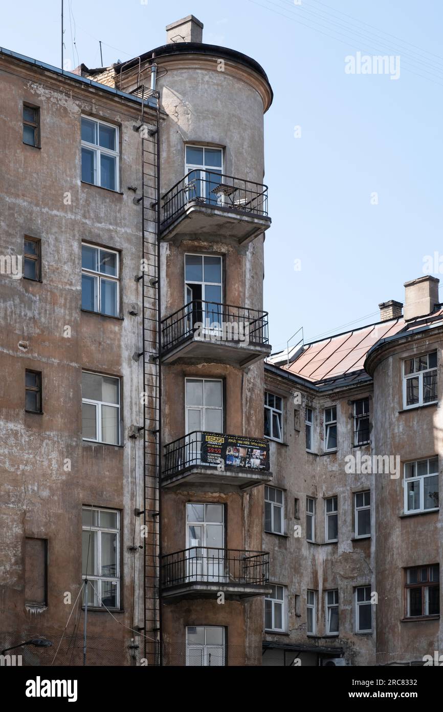 Ancienne façade patinée avec balcons sur un coin arrondi dans le centre de Riga, Lettonie Banque D'Images
