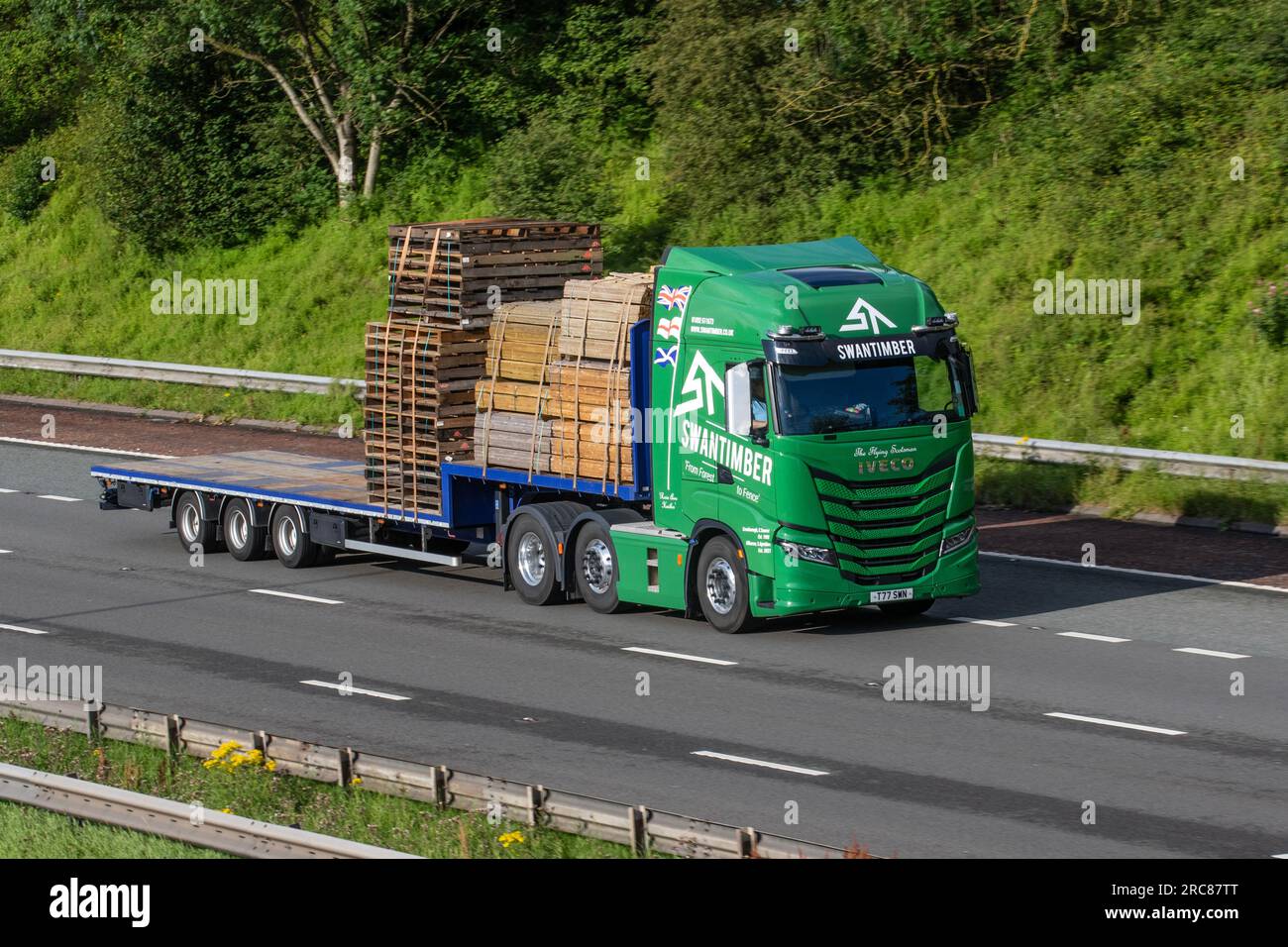 Camion Iveco à chargement bas SWAN TIMBER Ltd transportant des clôtures en bois résineux ; circulant sur l'autoroute M6 dans le Grand Manchester, au Royaume-Uni Banque D'Images