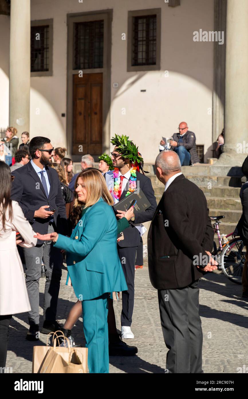 Florence, Italie - 5 avril 2022 : de jeunes diplômés célèbrent leurs diplômes avec une couronne de Laurier sur la tête sur la place SS Annunziata Banque D'Images