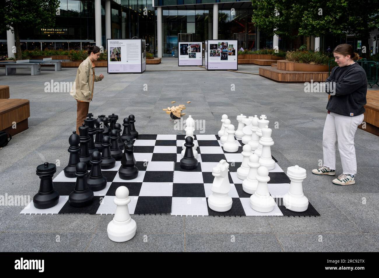 Londres, Royaume-Uni. 13 juillet 2023. Femmes jouant aux échecs géants en plein air à Euston avant le populaire Chess Fest, qui revient à Trafalgar Square le 16 juillet. L'événement célèbre le jeu d'échecs où les visiteurs peuvent apprendre le jeu, jouer aux échecs ou défier un grand maître et comprendra un jeu d'échecs vivant, avec 32 acteurs professionnels prenant le rôle des pièces d'échecs, pour donner vie au jeu. Crédit : Stephen Chung / Alamy Live News Banque D'Images