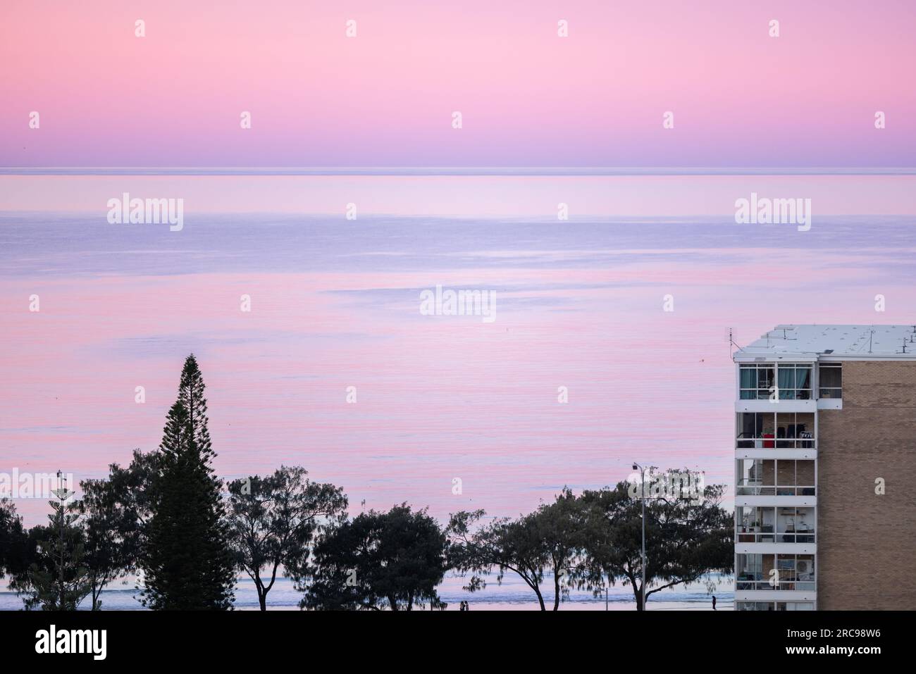 Appartement de grande hauteur en bord de mer près de la plage avec beau ciel rose au coucher du soleil Banque D'Images