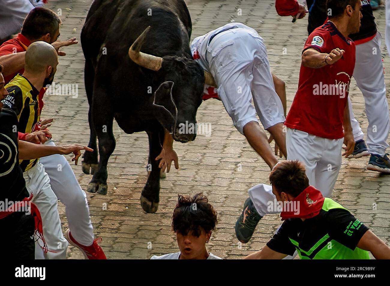 Pamplona, Espagne. 13 juillet 2023. Un jeune coureur est endeuillé par un taureau du ranch Victoriano del Río lors de la septième course des taureaux pendant les festivités de San Fermín en 2023. Septième course des taureaux à Pampelune pendant les festivités de San Fermín, six taureaux du ranch Victoriano del Rio ont parcouru les 850 mètres pour atteindre les arènes de Pampelune en 2 minutes et 18 secondes, laissant plusieurs blessés par des contusions sur leur chemin. La course des taureaux en a laissé un orné par un cornet. (Photo Elsa A Bravo/SOPA Images/Sipa USA) crédit : SIPA USA/Alamy Live News Banque D'Images