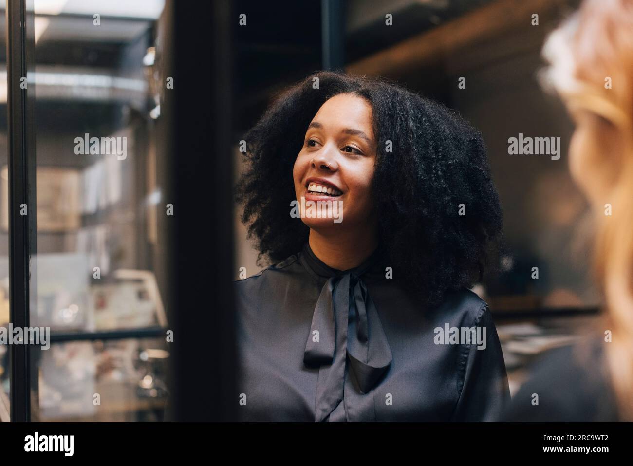 Femme d'affaires heureuse avec coiffure afro dans le bureau Banque D'Images