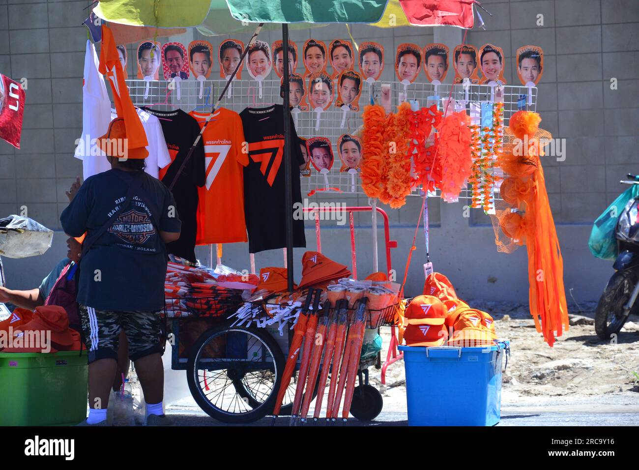 Les marchandises en vente sur l'un des nombreux étals de marché à proximité présentent l'image de Pita Limjaroenrat et le thème orange. Manifestation près du Parlement, Bangkok, Thaïlande. Le Parlement thaïlandais vote le 13 juillet pour décider si le leader du parti Move Forward, Pita Limjaroenrat, qui a remporté le plus grand nombre de sièges aux élections de mai, peut devenir le nouveau Premier ministre, mettant fin à 9 ans de règne de l'ancien chef de l'armée Prayuth Chan-ocha. Banque D'Images