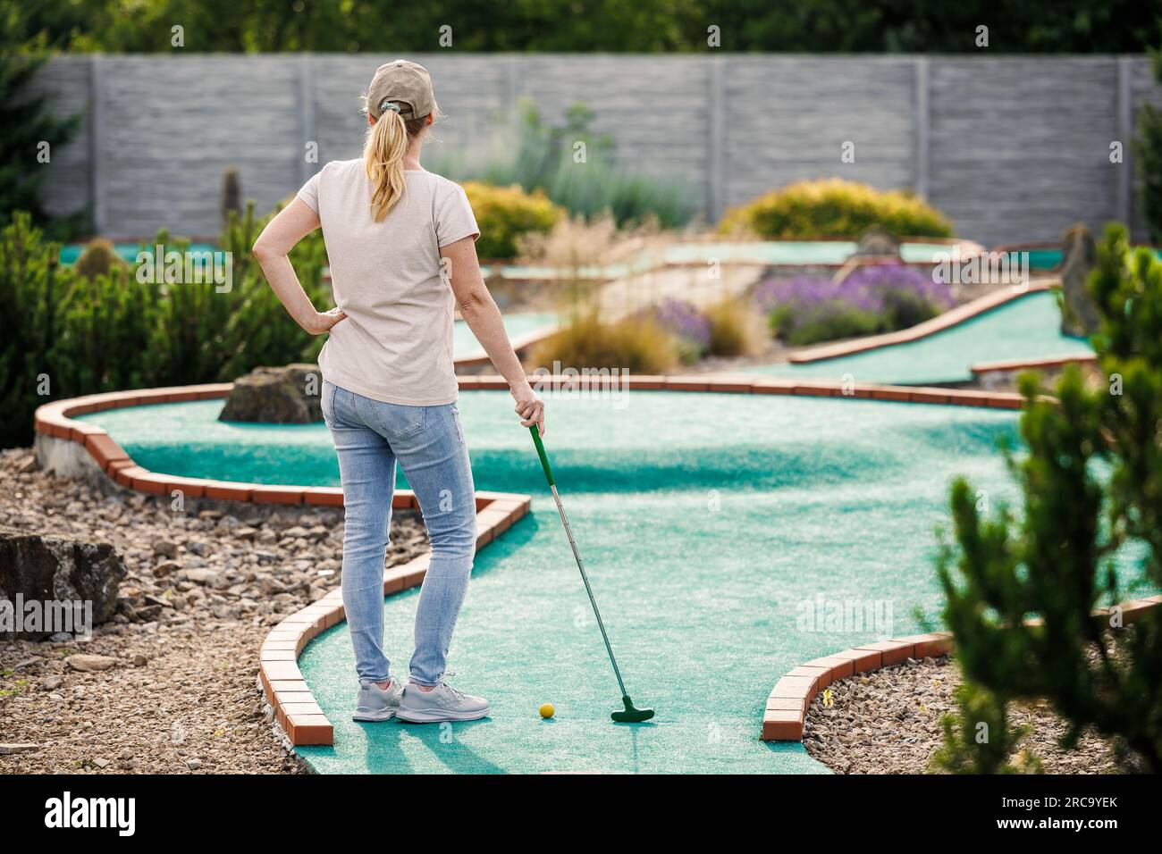 Femme jouant au mini-golf au cours. Activités sportives et de loisirs estivales Banque D'Images