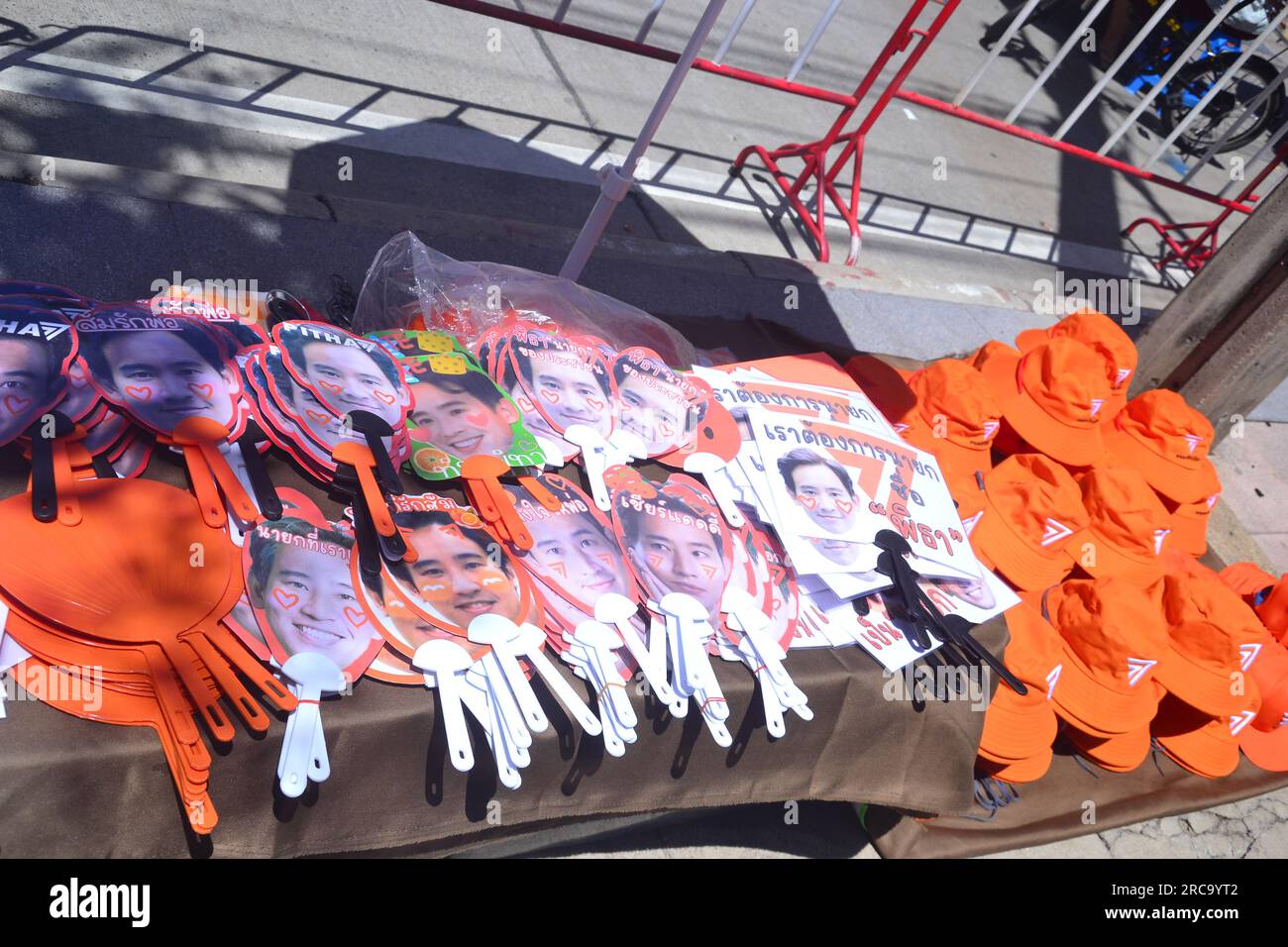 Les marchandises en vente sur l'un des nombreux étals de marché à proximité présentent l'image de Pita Limjaroenrat et le thème orange. Manifestation près du Parlement, Bangkok, Thaïlande. Le Parlement thaïlandais vote le 13 juillet pour décider si le leader du parti Move Forward, Pita Limjaroenrat, qui a remporté le plus grand nombre de sièges aux élections de mai, peut devenir le nouveau Premier ministre, mettant fin à 9 ans de règne de l'ancien chef de l'armée Prayuth Chan-ocha. Banque D'Images