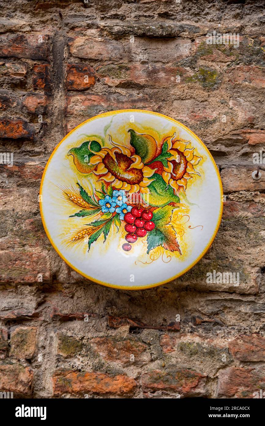 Produit artisanal typique, assiettes peintes à la main accrochées au mur d'une boutique de souvenirs à Sienne, Toscane, Italie. Banque D'Images