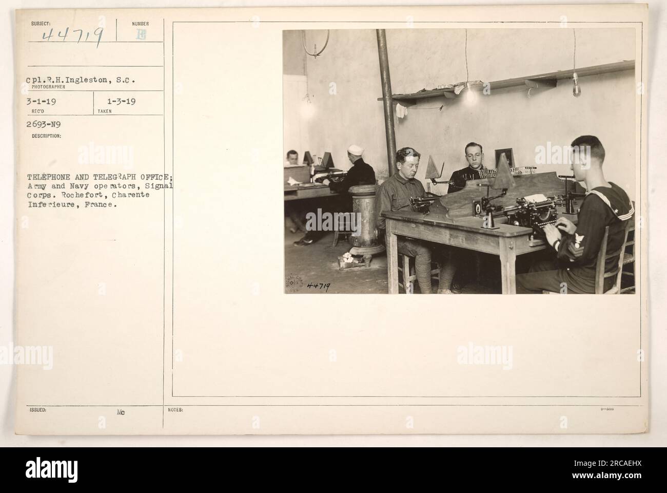 Soldats américains servant dans le signal corps posant devant un bureau de téléphone et de télégraphe à Rochefort, Charente Inferieure, France. La photographie a été prise le 1 mars 1919 par le caporal R.H. Ingleston. L'image, numérotée 44719, représente des opérateurs de l'armée et de la marine travaillant ensemble au bureau. Banque D'Images