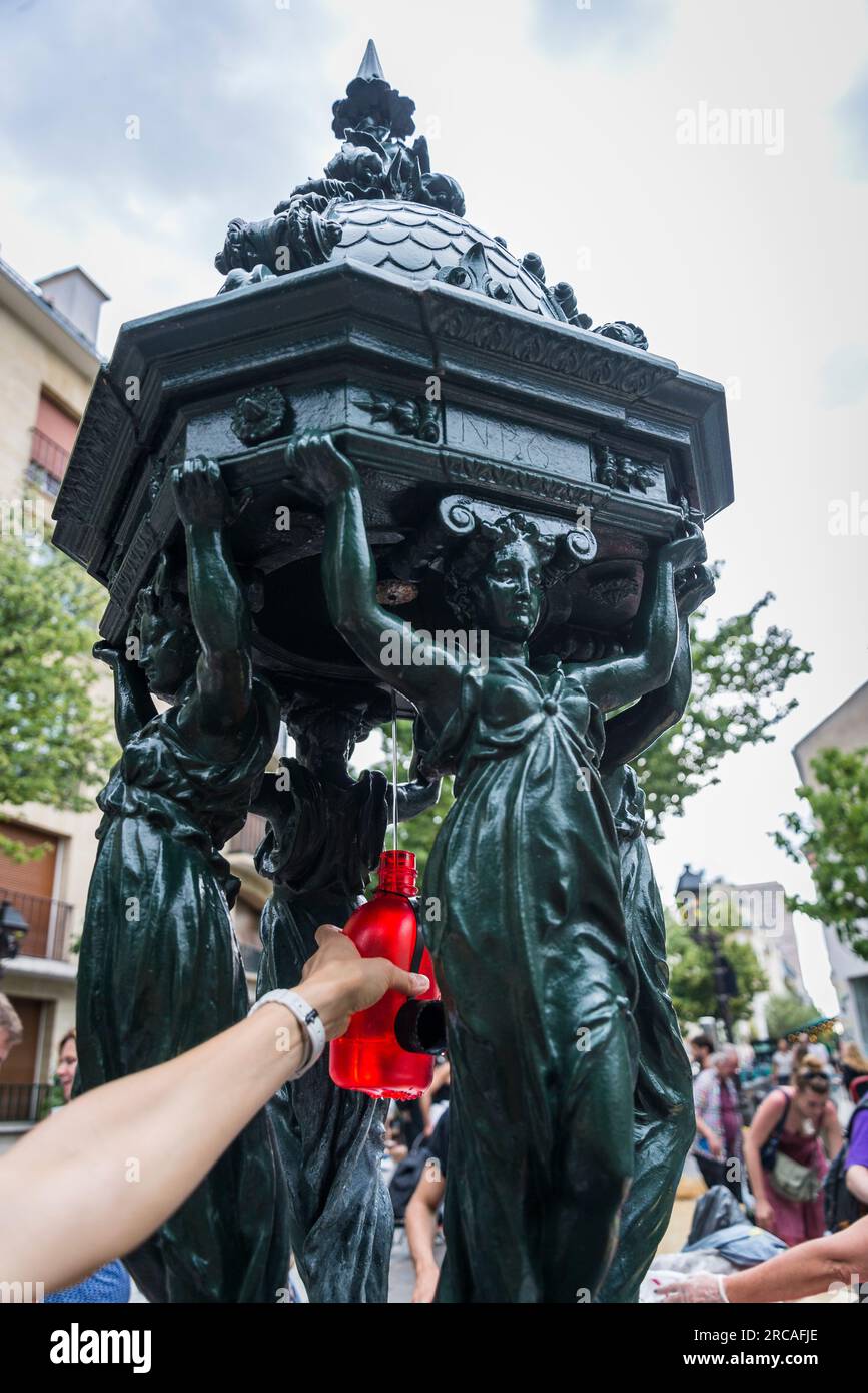 Femme remplissant sa bouteille à la fontaine Wallace. Ce sont des fontaines publiques nommées d'après, financées et conçues par Sir Richard Wall Banque D'Images
