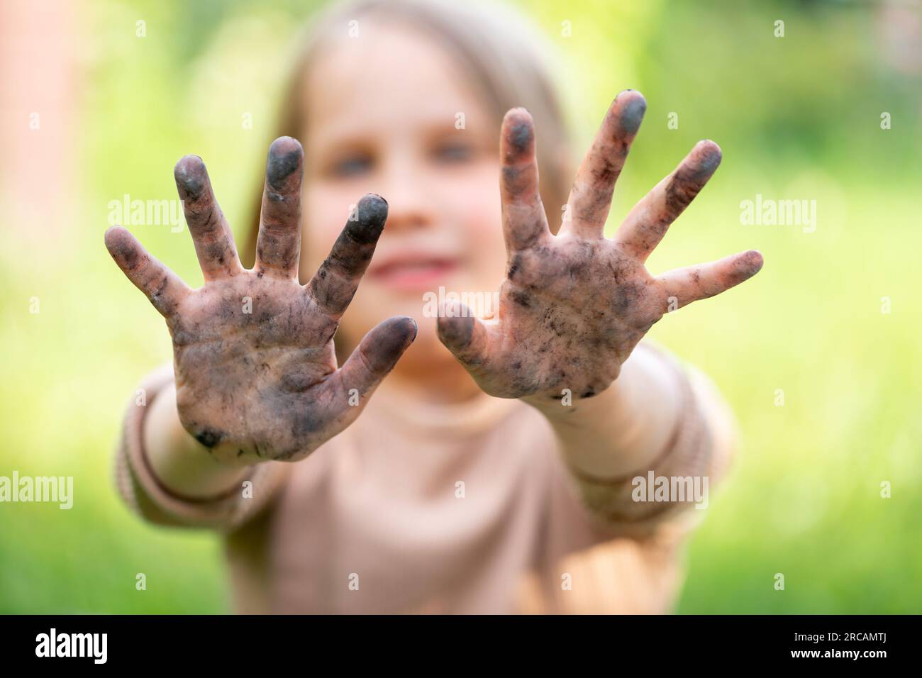 Petite fille montrant ses mains sales après une activité de plein air. Concept d'hygiène Banque D'Images