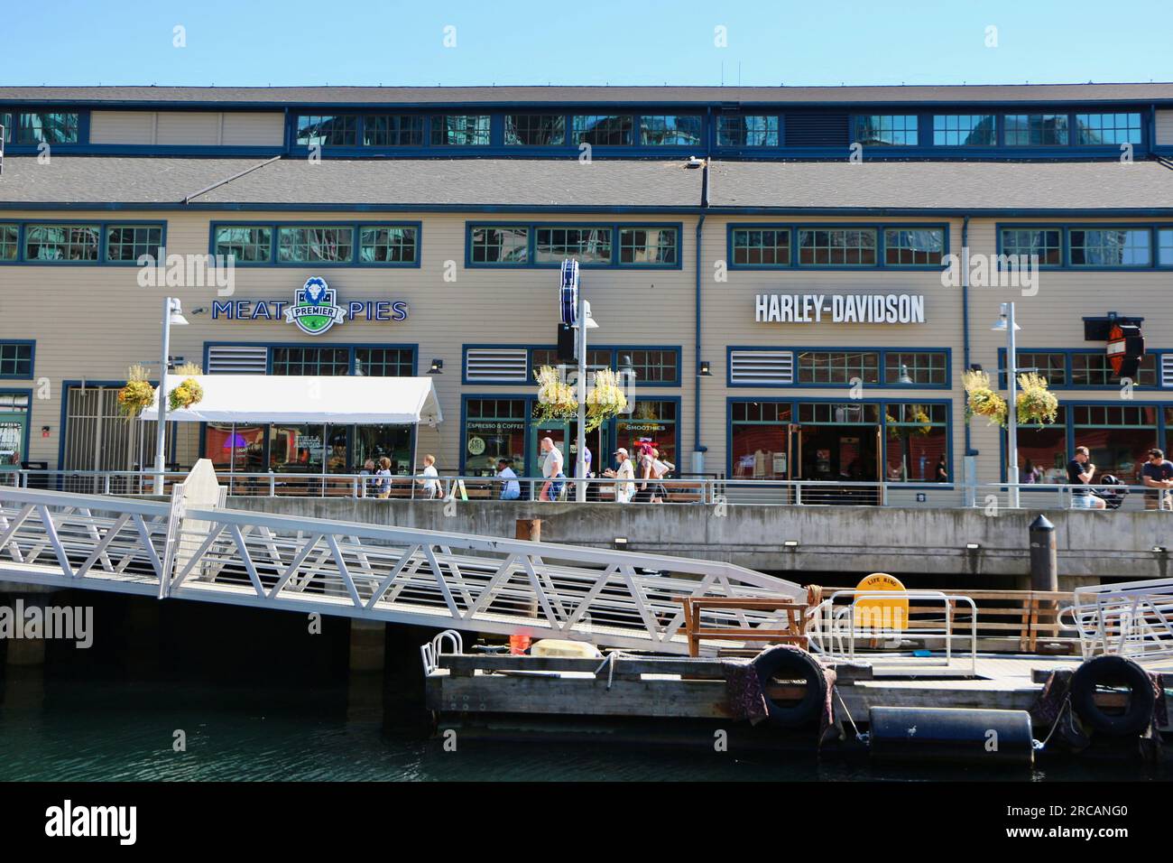 Touristes à l'embarcadère 54 avec restaurant Premier Meat Pies et Harley-Davidson Shop Alaskan Way Central Waterfront Seattle Washington State USA Banque D'Images