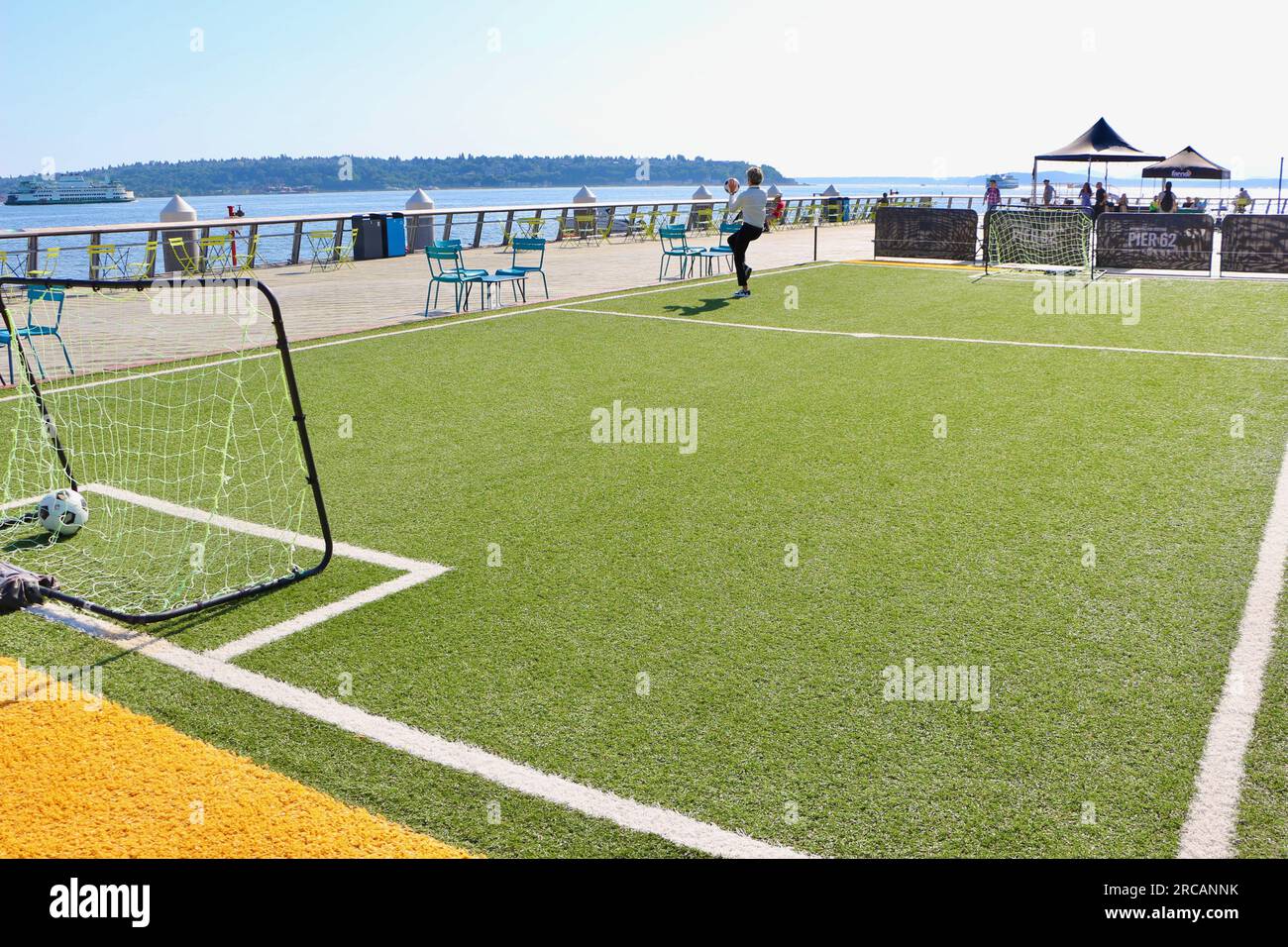 Un jeune jouant keepie uppie terrain de football avec gazon artificiel Pier 62 Alaskan Way Seattle Washington State USA Banque D'Images