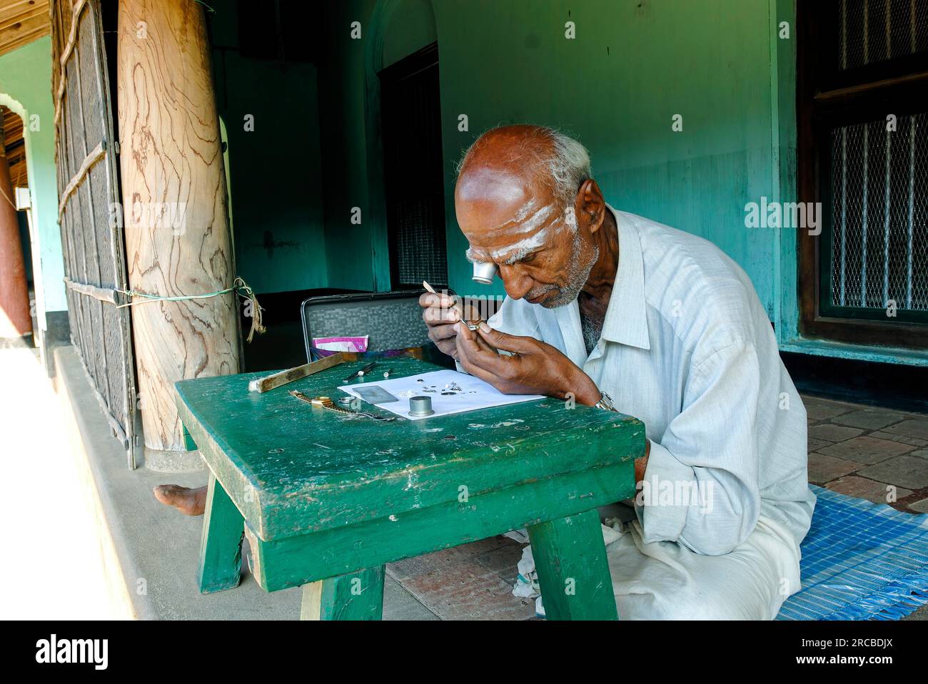 Un vieil homme réparateur de montres assis devant une maison Agraharam maison brahmin à Konerirajapuram près de Kumbakonam, Tamil Nadu, Inde du Sud, Inde, Asie Banque D'Images