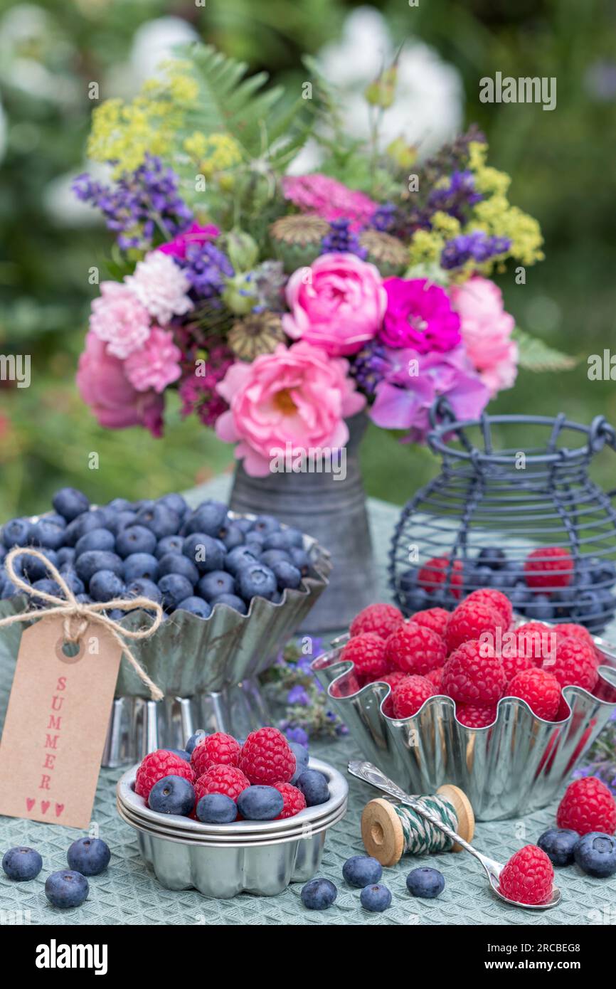 arrangement de table avec des framboises fraîches et des bleuets dans des casseroles vintage Banque D'Images