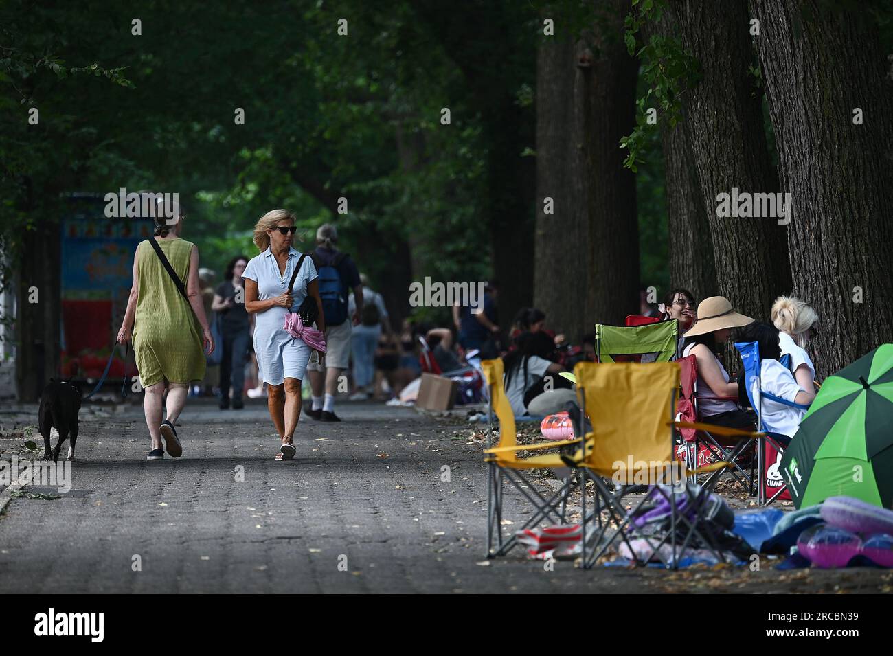 New York, États-Unis. 13 juillet 2023. Une femme marchant sur la 5e Avenue regarde les fans du membre du BTS Jung Kook campé devant Central Park depuis plusieurs jours pour assister à son concert du vendredi, New York, NY, le 13 juillet 2023. (Photo Anthony Behar/Sipa USA) crédit : SIPA USA/Alamy Live News Banque D'Images