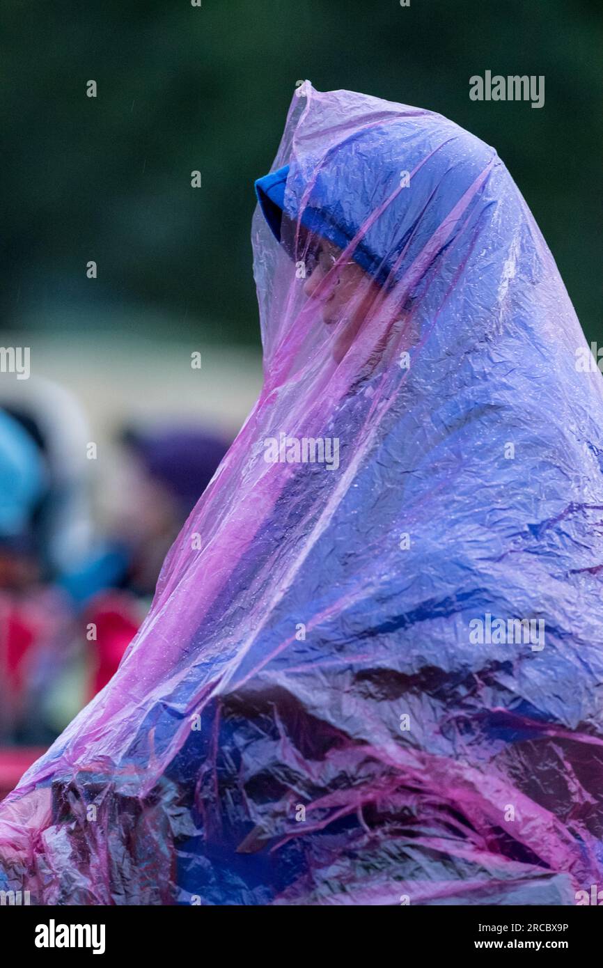 Les festivaliers du festival de musique GTSF se couvrent pendant une brève averse de pluie. Banque D'Images
