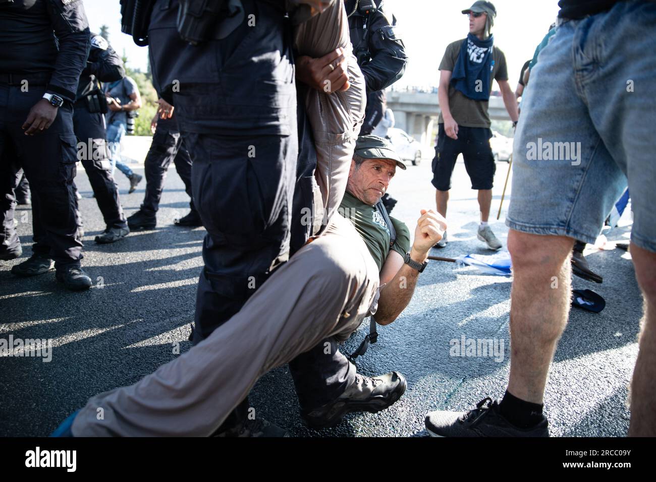 Jérusalem, Israël. 11 juillet 2023. Un officier de police tire un manifestant de la route lors d'une manifestation de réservistes israéliens contre la réforme judiciaire au cours de laquelle les manifestants ont bloqué l'autoroute tel Aviv-Jérusalem à la jonction Ein Hemed. (Image de crédit : © Matan Golan/SOPA Images via ZUMA Press Wire) USAGE ÉDITORIAL SEULEMENT! Non destiné à UN USAGE commercial ! Banque D'Images