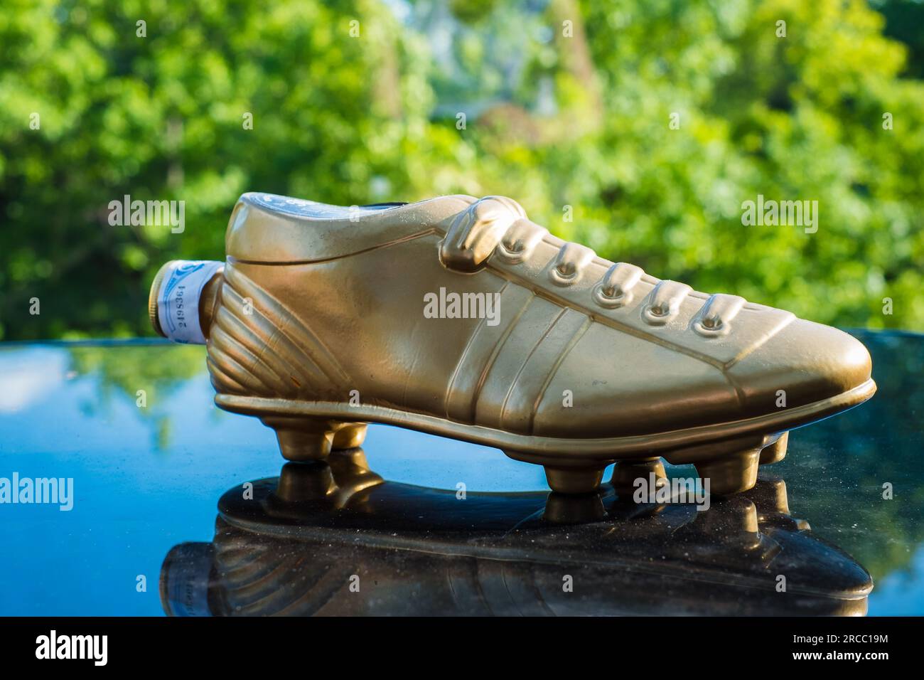Tartu, Estonie - 8 juillet 2023 : Whisky doré de la Dream Team (Bota d'Or). Bouteille cadeau en forme de chaussure de football ou de football dorée. Banque D'Images