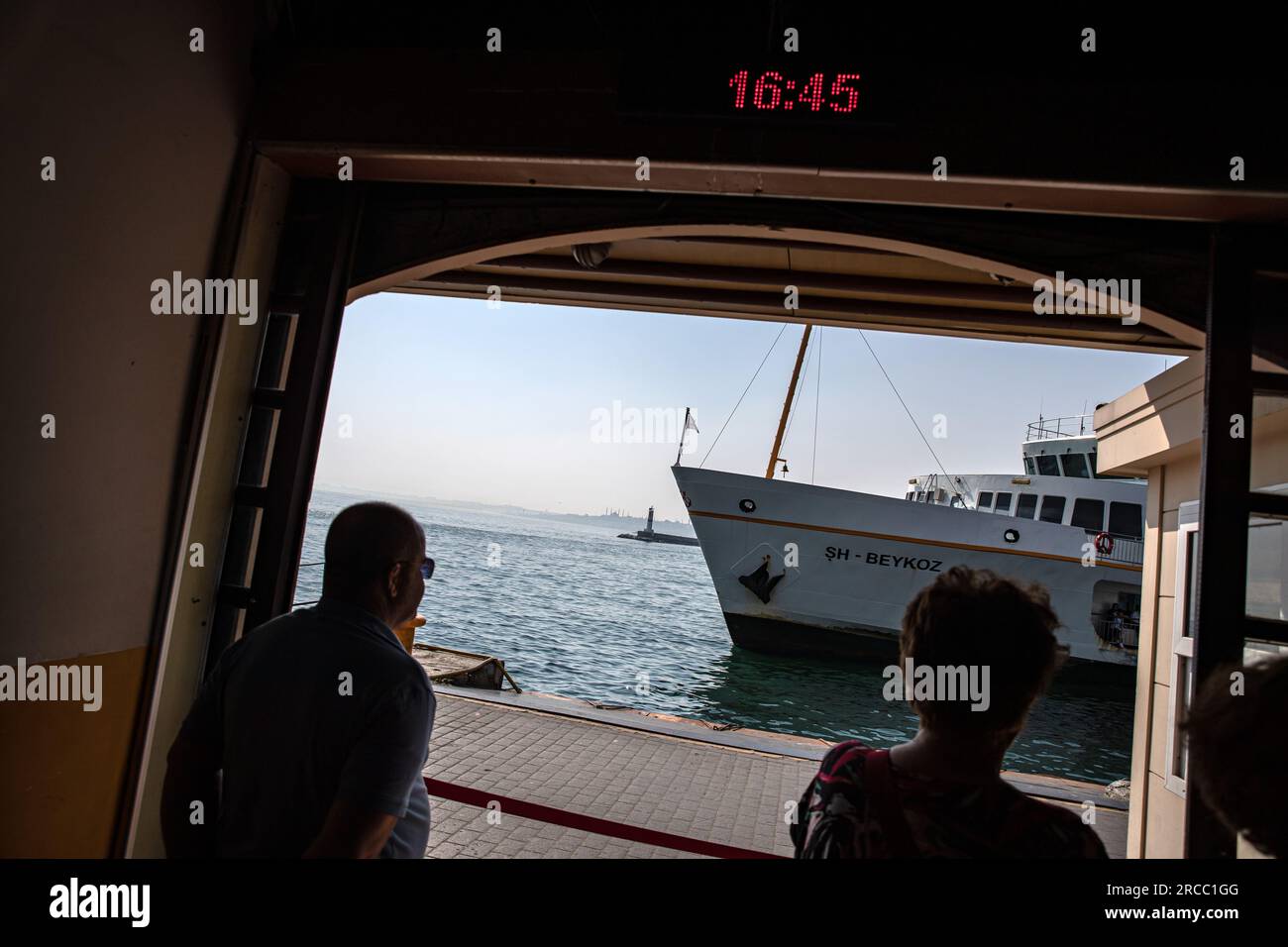 Les gens attendent de monter à bord d'un ferry amarré à l'embarcadère de ferry de Kadikoy City Lines pendant la chaleur à Istanbul. Banque D'Images