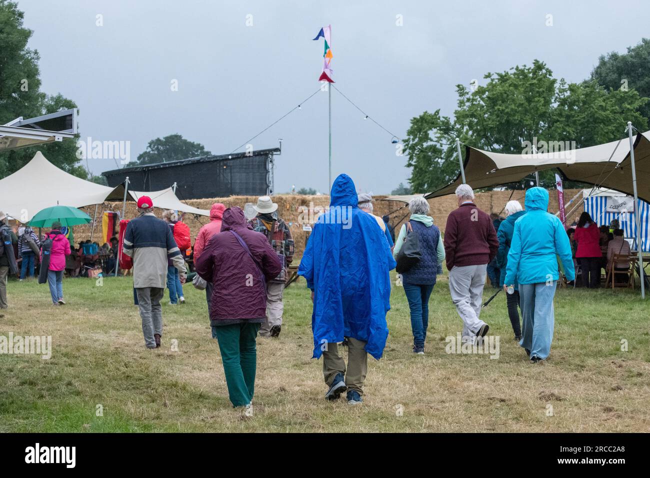 Les festivaliers du festival de musique GTSF se couvrent pendant une brève averse de pluie. Banque D'Images