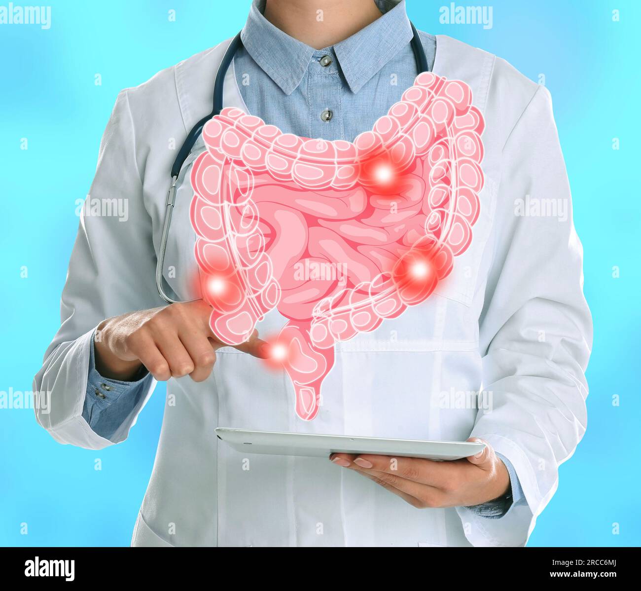 Gastro-entérologue tenant l'ordinateur tablette sur fond bleu clair, gros plan. Illustration des intestins avec des taches sur le dispositif Banque D'Images