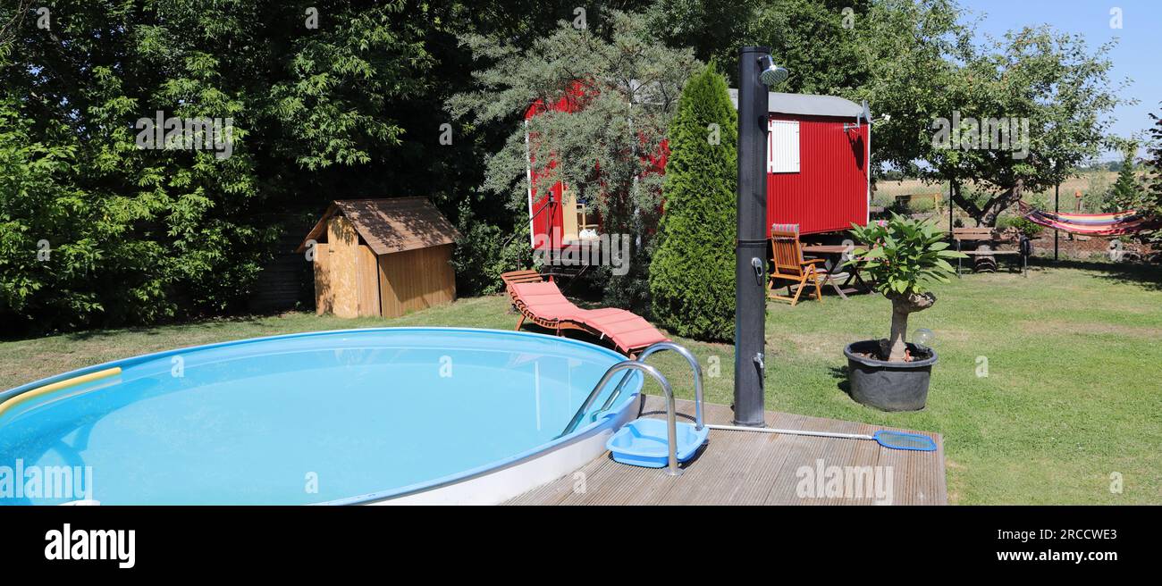 une remorque rouge avec un transat près de la piscine Banque D'Images