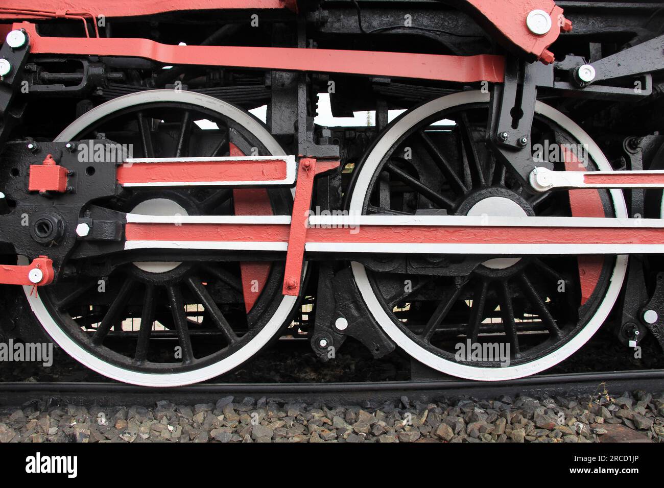 Détail des roues métalliques de la locomotive de train. Les roues sont peintes en noir, blanc et rouge. Banque D'Images