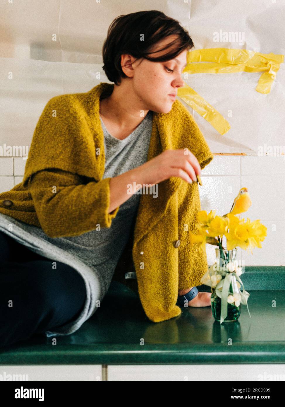 Une femme habillée de jaune entourée d'un désordre chaotique yello. Banque D'Images