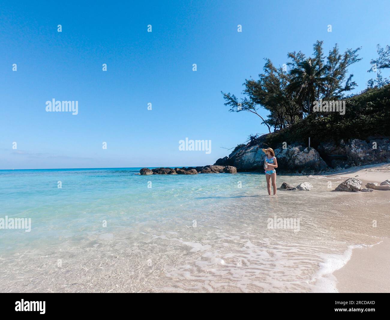 Adolescente debout dans l'eau claire des Bahamas portant un maillot de bain Banque D'Images