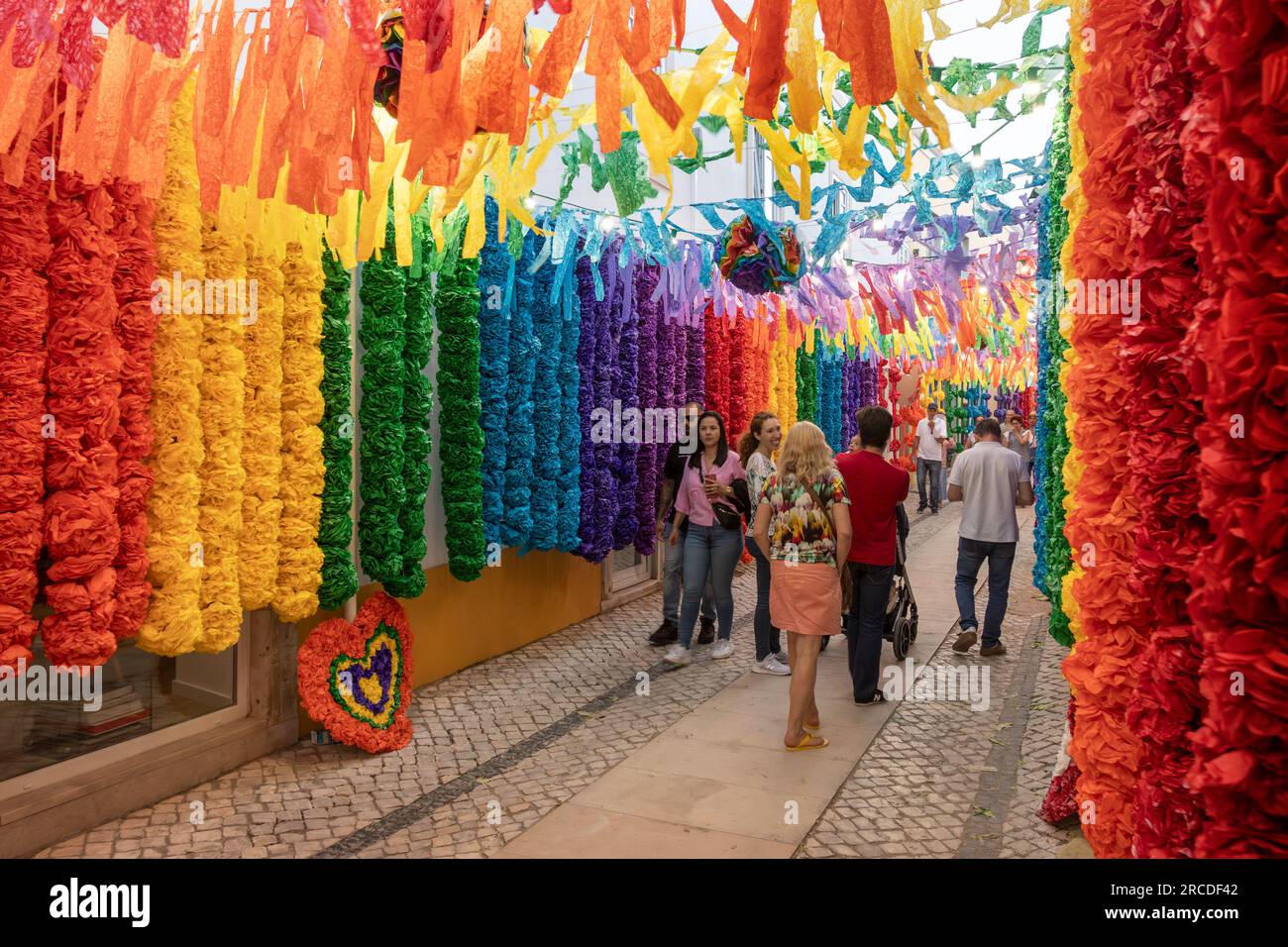 Tomar, Portugal - 8 juillet 2023 : rue de la ville de Tomar au Portugal, décorée de couleurs arc-en-ciel sur des fleurs en papier pendant la Festa dos Tabuleiro Banque D'Images