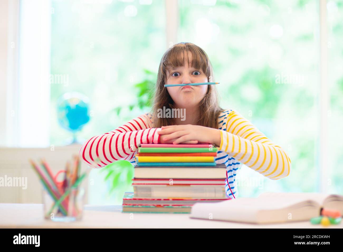 Enfant faisant ses devoirs à la maison. Petit enfant avec des livres colorés lisant et faisant des exercices mathématiques. Les enfants étudient et apprennent. Écolier avec écriture de livres Banque D'Images