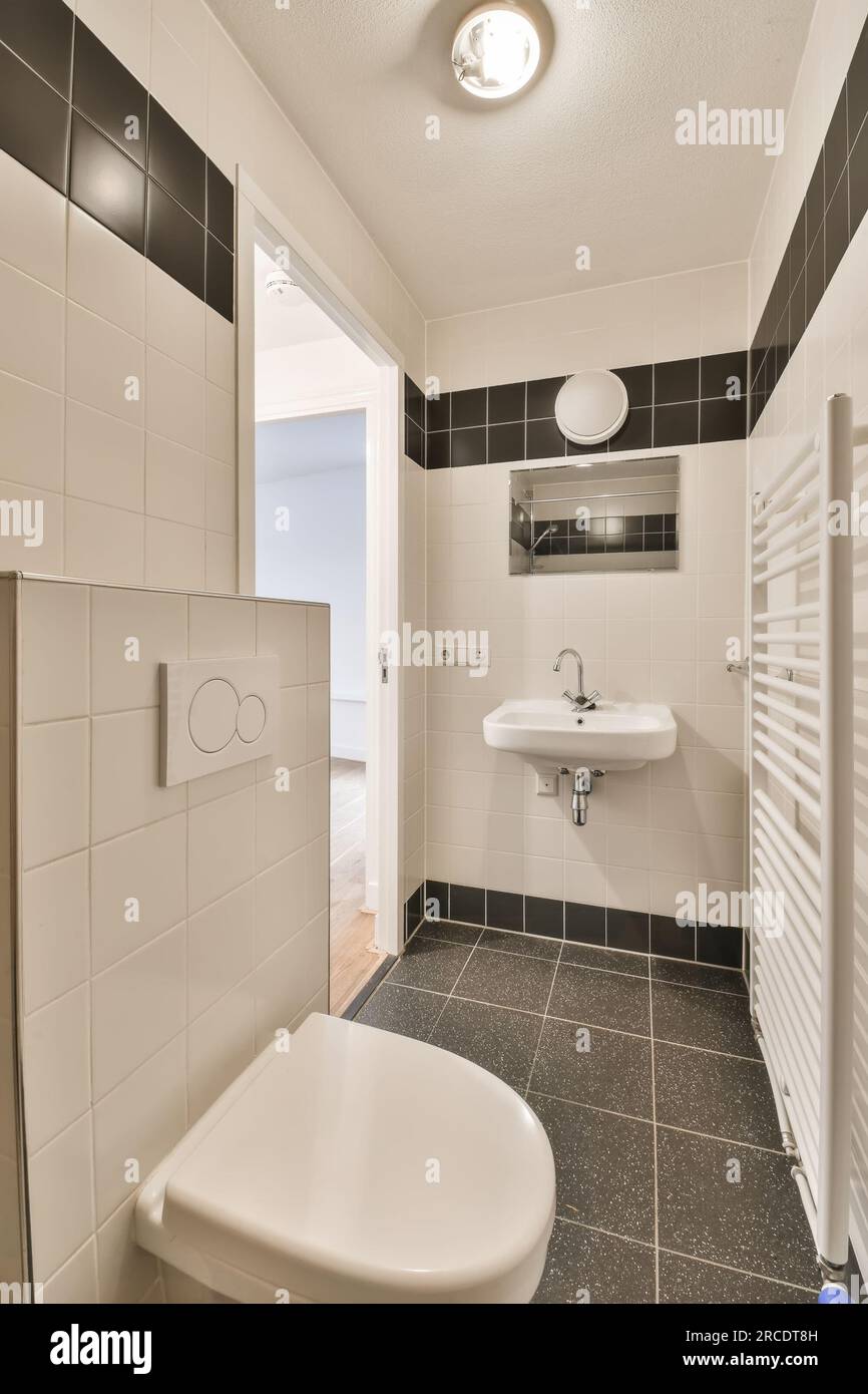 une petite salle de bain avec carrelage noir et blanc sur les murs, wc et  lavabo sont visibles dans cette image prise de dessus Photo Stock - Alamy