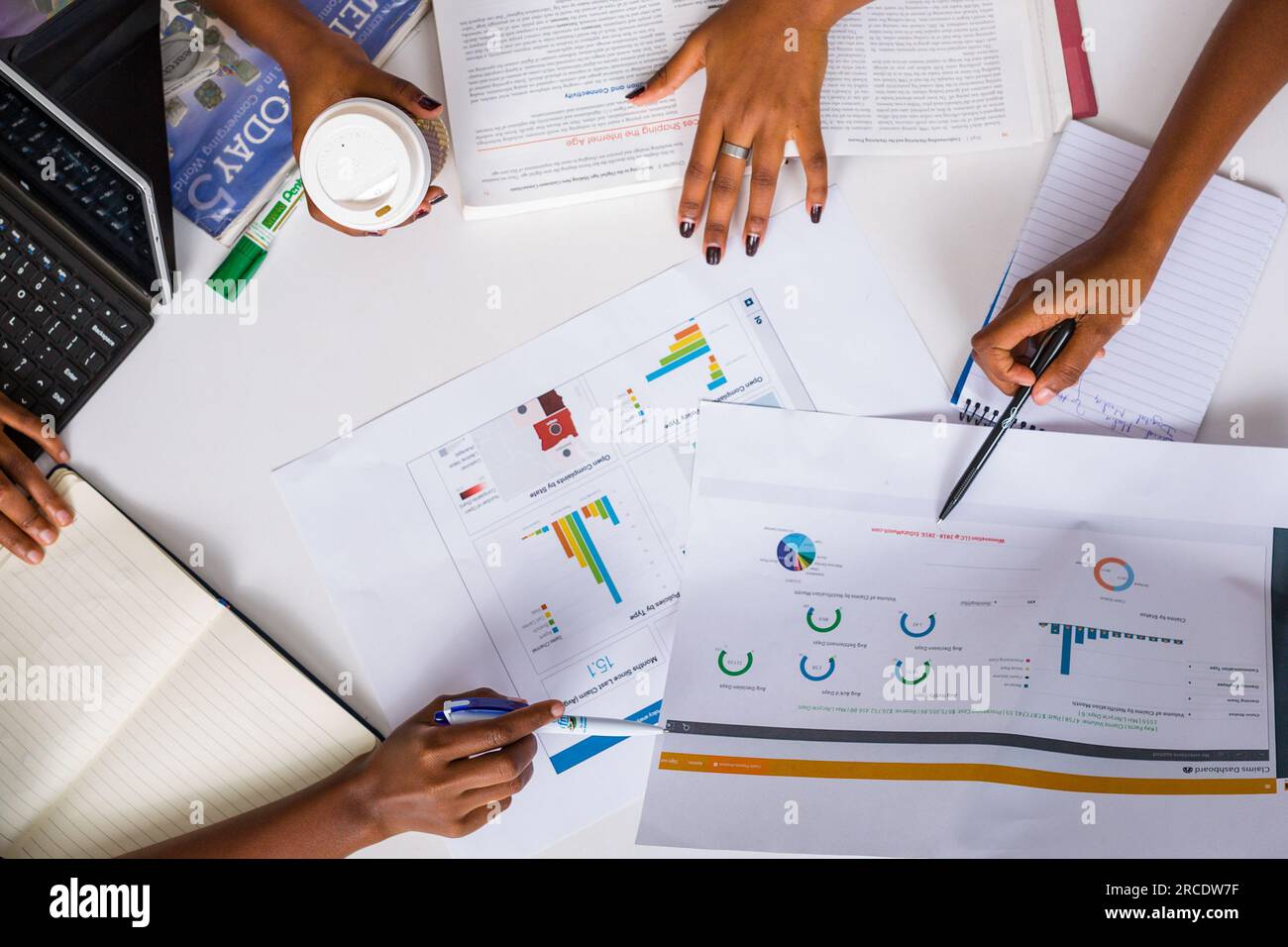 Les mains touchant les illustrations du tableau des tartes à plat reposent sur la table des discussions en table ronde Banque D'Images