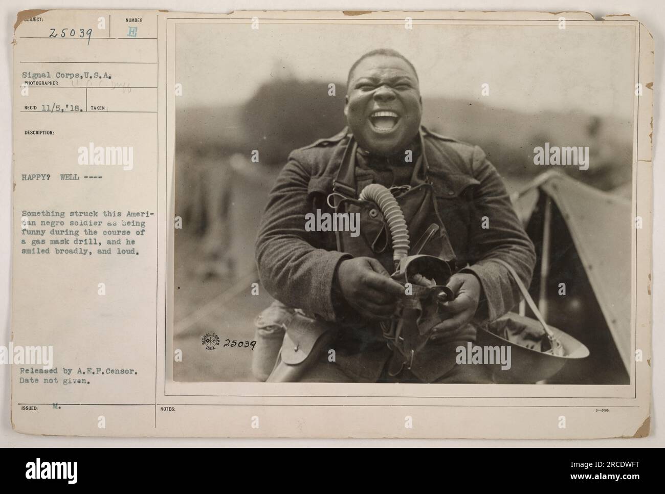 Soldat afro-américain souriant pendant un exercice avec masque à gaz. Le soldat trouva quelque chose d'amusant et ne put s'empêcher de sourire. Photographie prise par le photographe de signal corps, date inconnue. Publié par A.E.P. Censor. Numéro d'image : 25039.' Banque D'Images