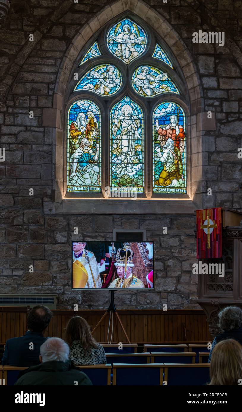 Personnes regardant le couronnement du roi Charles III sur écran de télévision, église paroissiale St Mary, Haddington, East Lothian, Écosse, Royaume-Uni Banque D'Images