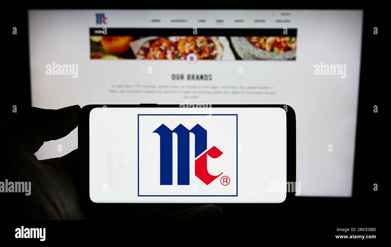 Personne tenant un smartphone avec le logo de la société américaine McCormick Company Incorporated sur l'écran devant le site Web. Concentrez-vous sur l'affichage du téléphone. Banque D'Images