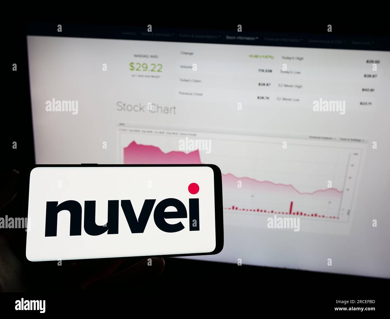 Personne tenant le téléphone mobile avec le logo de la société de paiements Nuvei technologies Corp. sur l'écran en face de la page Web. Concentrez-vous sur l'affichage du téléphone. Banque D'Images