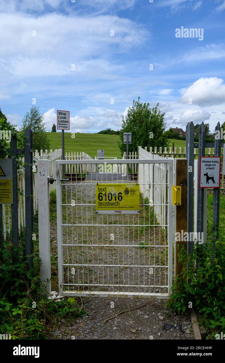 Portail blanc sur un passage à niveau piétonnier sur une ligne de chemin de fer britannique Banque D'Images