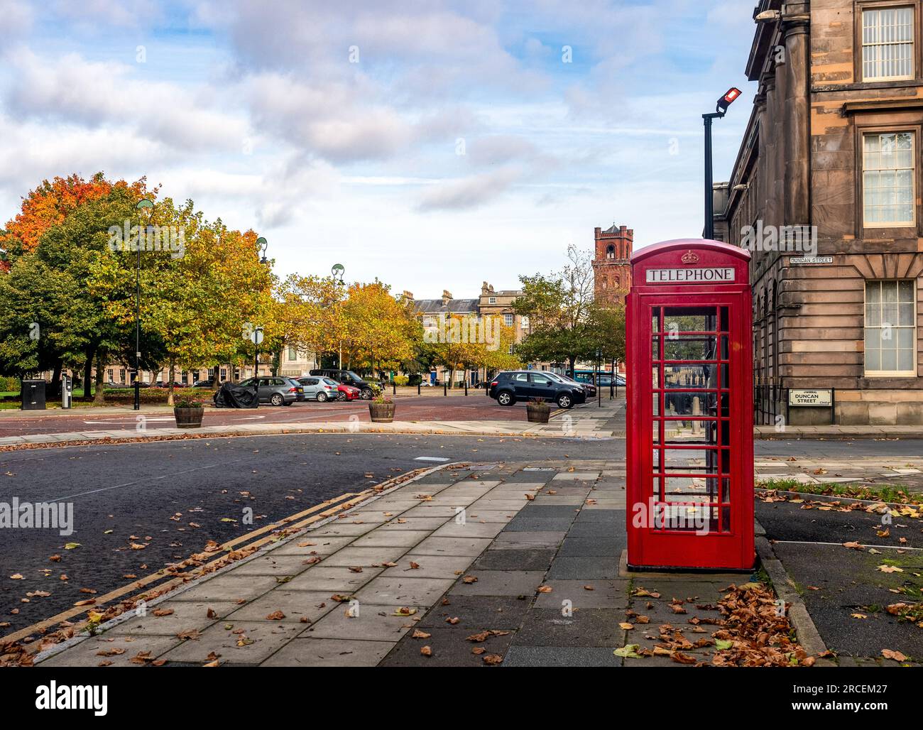 Boîte téléphonique britannique traditionnelle, Hamilton Square, Birkenhead, Royaume-Uni en automne Banque D'Images